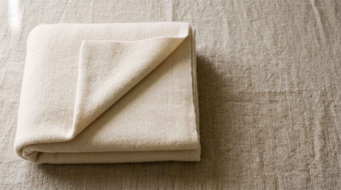 Folded cashmere blanket showing fine wool texture, illustrating genuine cashmere fiber quality.