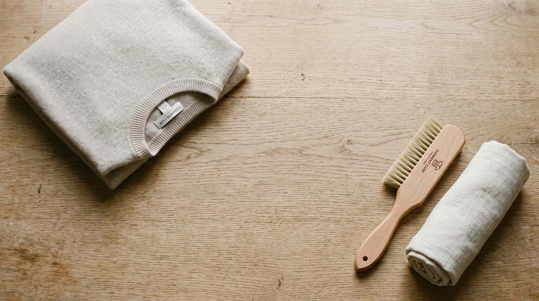 Folded cashmere garment with a soft brush, illustrating gentle cashmere care.