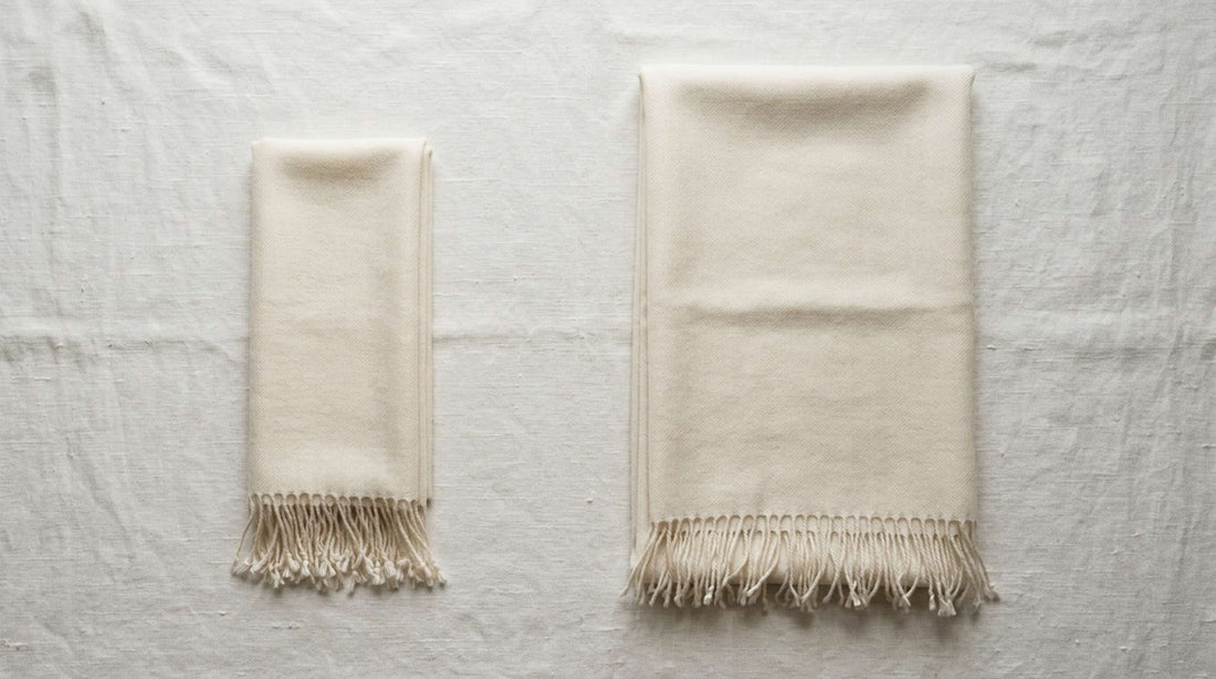 Pashmina scarf and pashmina shawl folded side by side, showing the size difference between the two.
